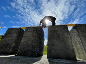 The sun shines on a daring dancer as he embraces a backbend outside the market.