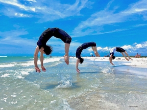 När vi förbereder oss för Floridas föreställningar, är ett avkopplande besök på stranden ett måste. De manliga dansarna gör volter ut i bränningarna, nästan som delfiner som svävar över vågorna.