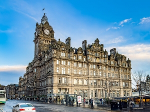 Le Balmoral, hôtel cinq étoiles emblématique d'Édimbourg, se dresse majestueusement au devant d’un ciel bleu clair.