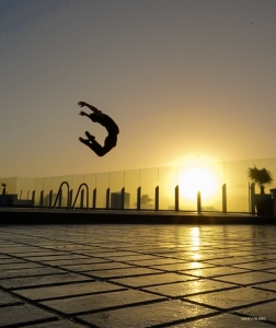 Een gedurfde danser springt hoog om boven de zon uit te komen. 