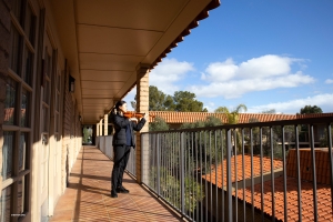 The best practice room is the one with a view. Concertmaster Freda Wang warms up her fingers on the hotel balcony in Tucson, Arizona.