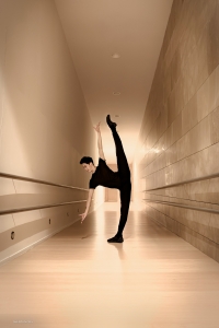 Next stop: Logroño, Spain. Principal dancer Piotr Huang prepares himself for performance in the hallway of RiojaForum.