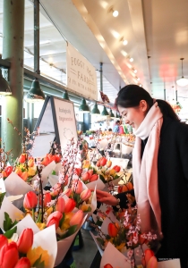 在西雅圖著名的派克市場，美麗的鮮花讓舞蹈演员 Yu Hui 流連。 