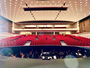 Widok na widownię w Kursaal Oostende w Belgii. Muzycy w orkiestronie ciężko pracują nad doskonaleniem swojego rzemiosła, aby wprawić publiczność w zachwyt.