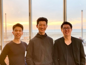 Im warmen Licht der Abenddämmerung genießen die Violinisten Hirofumi Kobayashi und Steven Song zusammen mit dem Dirigenten Chu Yun ihre Zeit am schönen Strand von Ostende, Belgien.