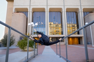 Die Tänzerin Emily Cui stellt mit einem Spagat auf den Geländern vor der Linda Ronstadt Music Hall in Tucson, Arizona, ihre unglaubliche Kraft und Flexibilität unter Beweis.