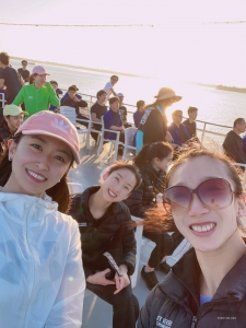 La maîtresse de cérémonie Nancy Zhang (à g.) et les premières danseuses Angela Lin (au centre) et Kaidi Wu (à dr.) prennent un selfie amusant lors de leur croisière en Floride.