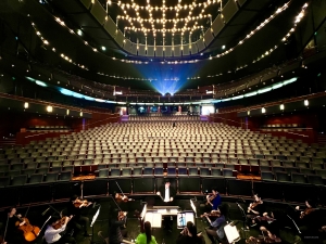 Admirez l'impressionnant auditorium de la Cité des Congrès de Nantes, en France, où nos musiciens répètent dans la fosse d'orchestre, prêts à enchanter le public avec leur superbe musique. 