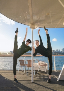 Who's the true straight shooter—the pole or the dancers? Our performers playfully challenge the vertical with their impeccable leg alignment.