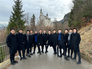 In the crisp alpine air, male dancers prepare to hike up to the enchanting Neuschwanstein Castle, once the dream of King Ludwig II, known as the 'Fairy Tale King'.