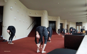 In the lobby of Stadthalle Mülheim an der Ruhr in Germany, dancers practice flexing their backs—a crucial skill in classical Chinese dance, where fluid movements and graceful lines intertwine.