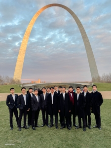 Bathed in the glow of dusk, our male dancers stand before the Gateway Arch in St. Louis, Missouri. Rising 630 feet (192 meters) into the sky, this monumental structure, clad in stainless steel, is the world's tallest arch.