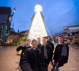 Holiday lights and warm smiles brighten an evening stroll through Birmingham, England. 