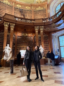 The Austrian National Library, located in the Hofburg Palace in Vienna, is Europe's largest Baroque library. Dancers Diana Tseng and Shindy Cai admire the ornate frescos of the State Hall (Prunksaal), considered one of the world's most beautiful library interiors.