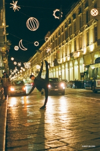 A dancer cuts a graceful silhouette against the magical lights of Luci d'Artista, an open-air art installation in Turin, Italy.
