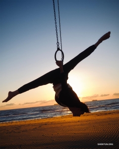 Back in Virginia Beach, a dancer tests his aerial skills on a set of traveling rings. 